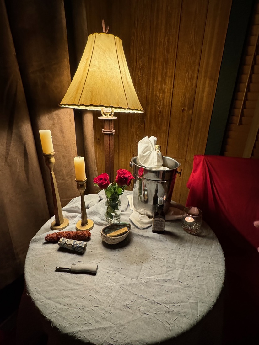 A candlelit table with red roses