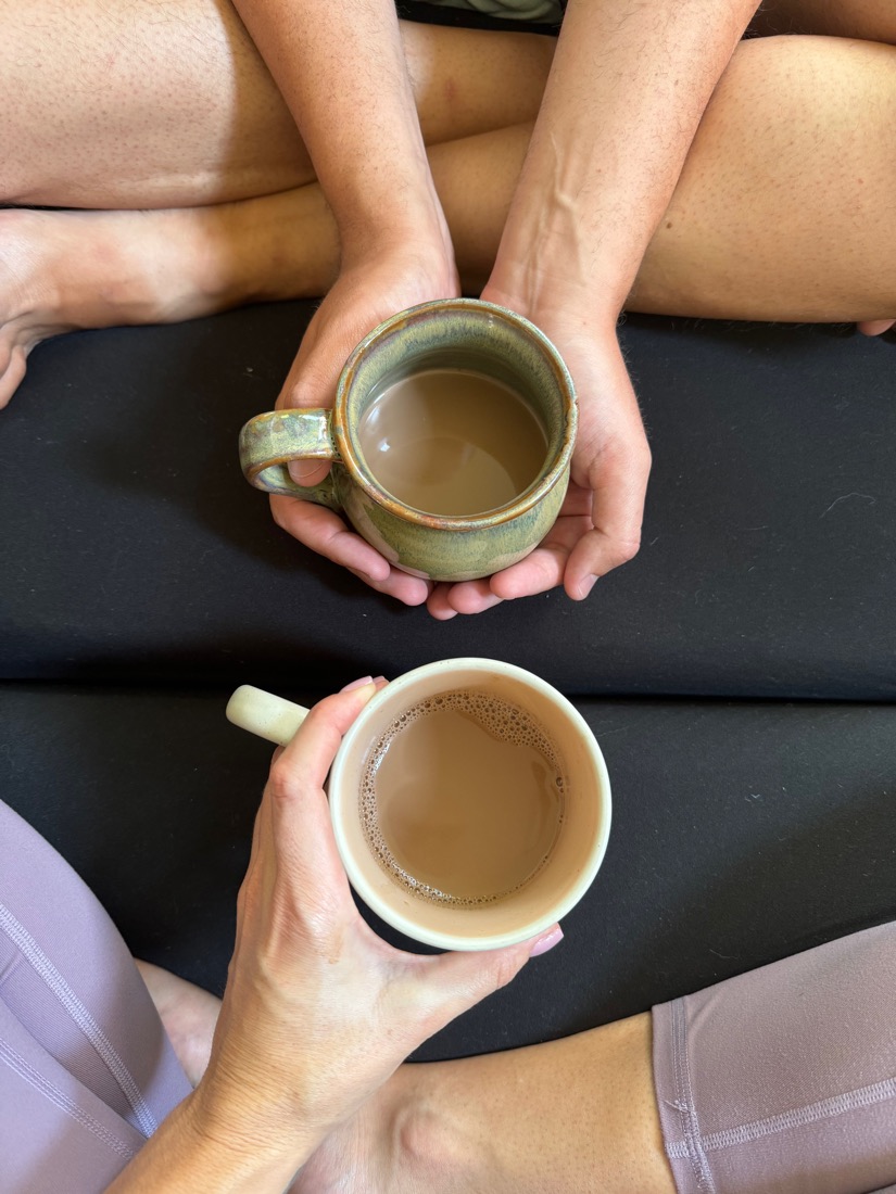 Two pairs of hands holding cups of tea